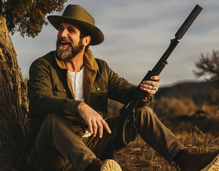 Man with suppressed rifle